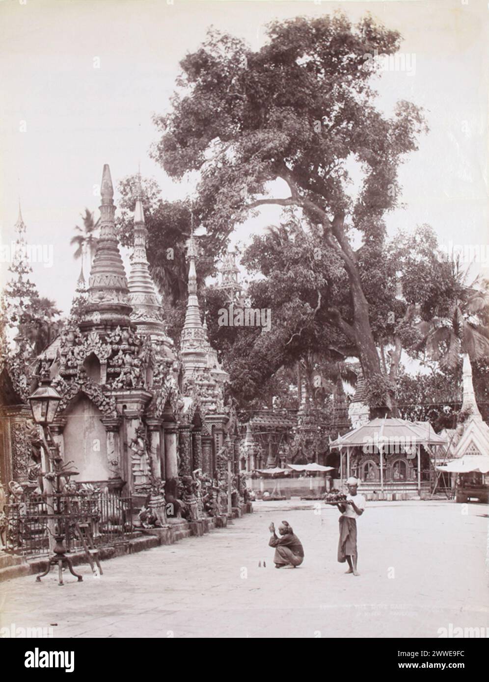 Una fotografia del 1906 di Philip Klier raffigurante una scena alla pagoda Shwe Dagon a Rangoon, Birmania. L'immagine mostra le strutture del tempio e i visitatori in uno dei più importanti siti buddisti in Myanmar. Foto Stock