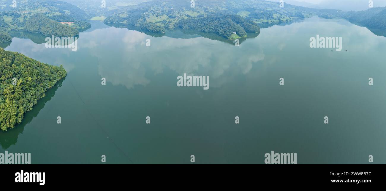 Vista aerea del lago Begnas, il terzo lago più grande del Nepal. Natura selvaggia e alberi con case circondano il lago, tipiche barche nepalesi in acqua Foto Stock