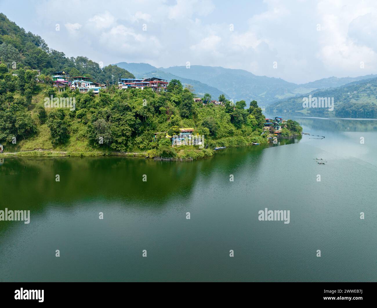 Vista aerea del lago Begnas, il terzo lago più grande del Nepal. Natura selvaggia e alberi con case circondano il lago, tipiche barche nepalesi in acqua Foto Stock