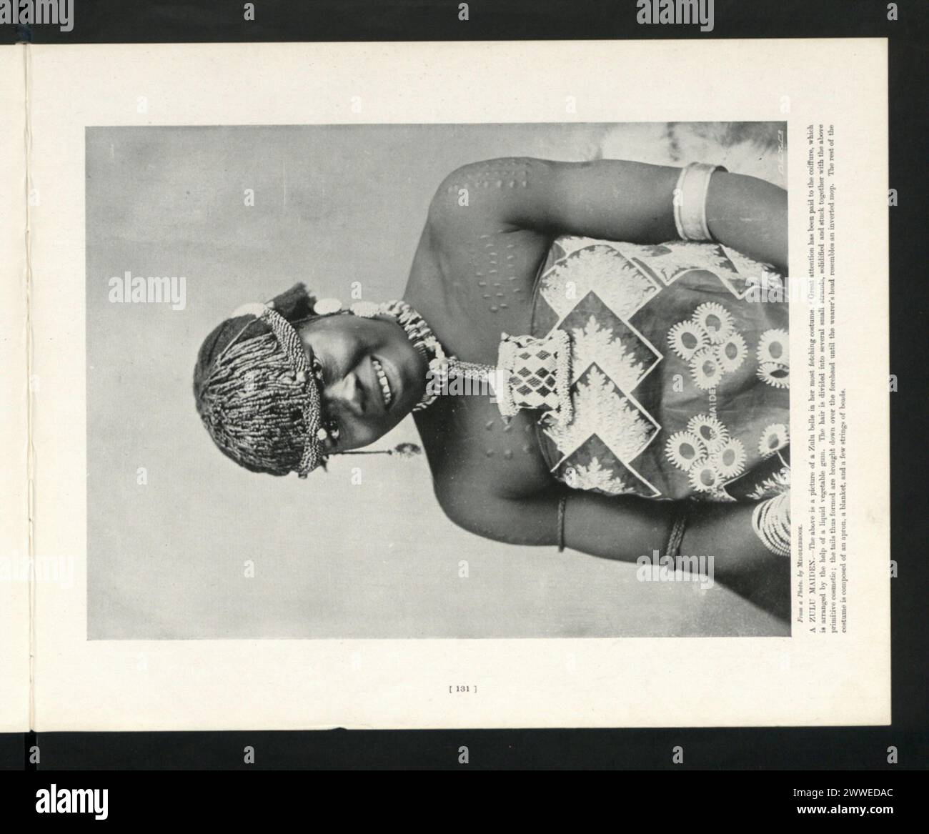 Una fanciulla zulu in Sud Africa, raffigurata in abiti tradizionali, che rappresenta l'identità culturale locale. Foto Stock