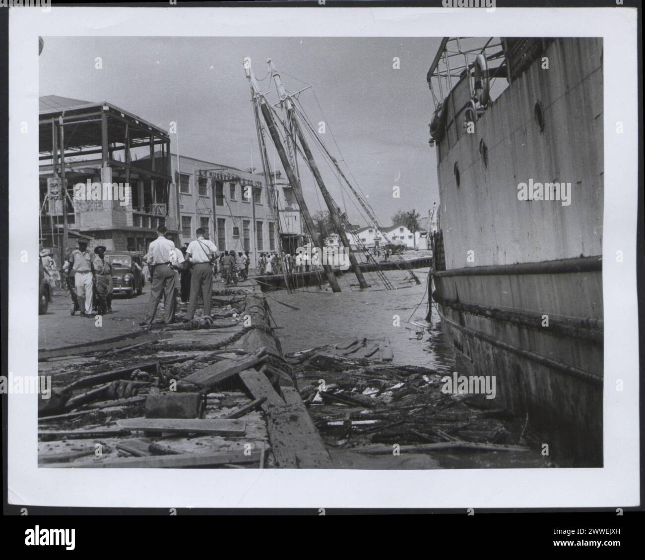 Il lato della banchina delle Barbados era coperto di detriti e cinque piccole imbarcazioni furono affondate durante l'uragano Janet nel 1955. Foto Stock