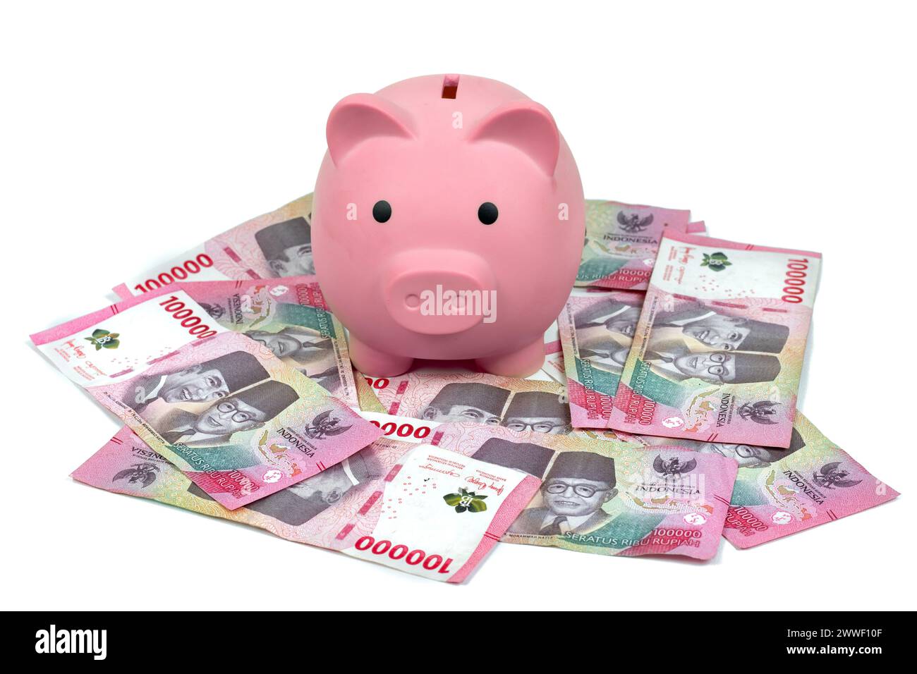 Valuta indonesiana. Piggy Bank con mucchio di Rupia o 100.000 IDR isolati su sfondo bianco Foto Stock