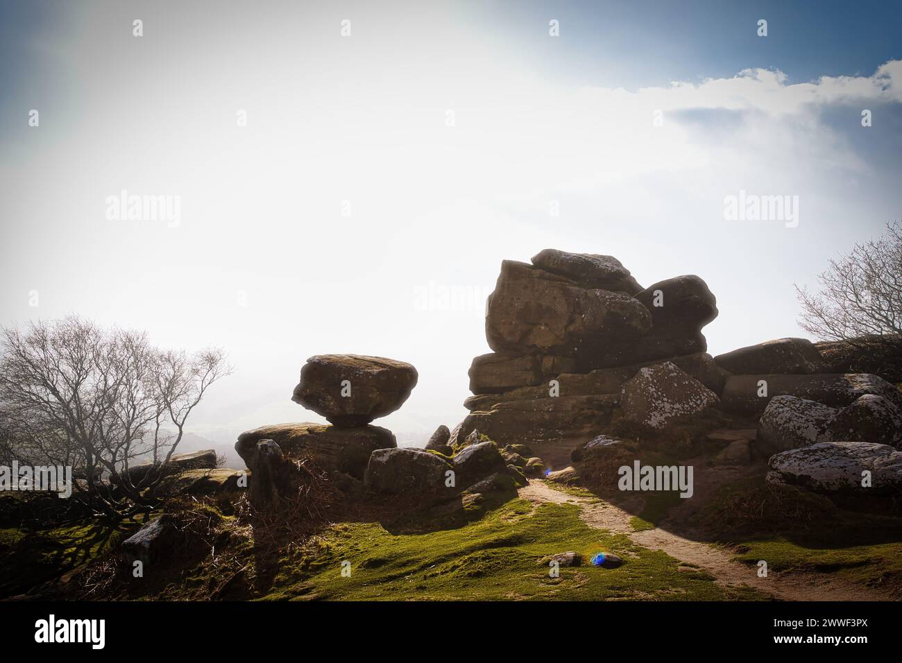 Paesaggio nebbioso con formazioni rocciose bilanciate e un percorso limpido sotto un cielo luminoso a Brimham Rocks, nel North Yorkshire Foto Stock