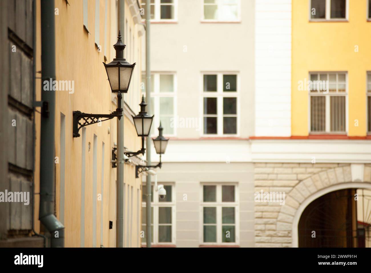 Un vecchio lampione buio con inserti in vetro è appeso al muro di una casa a Tallinn. Foto di alta qualità Foto Stock