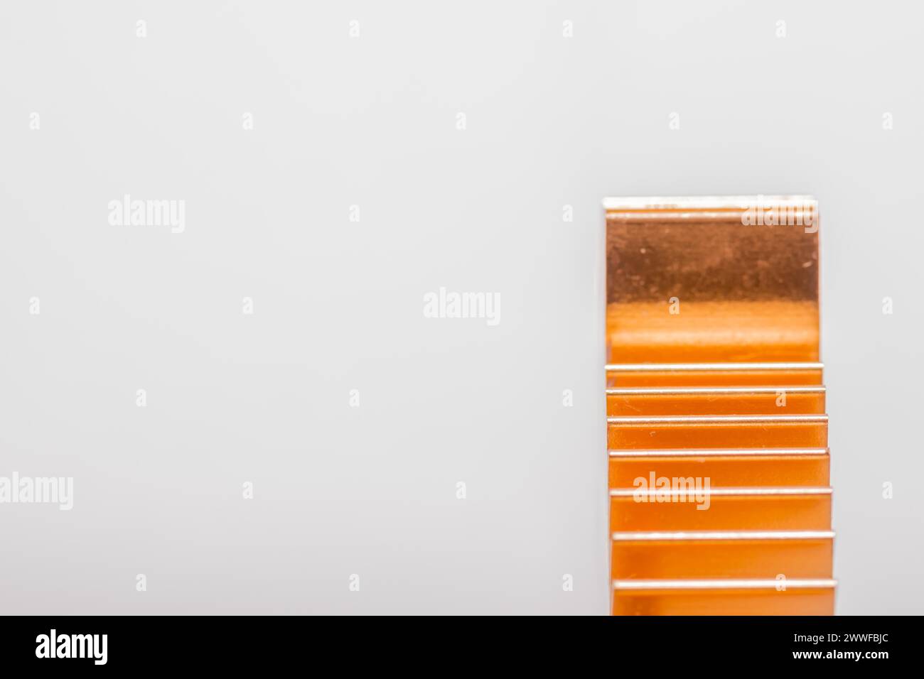 Primo piano delle alette del dissipatore di calore per computer in rame su sfondo bianco Foto Stock