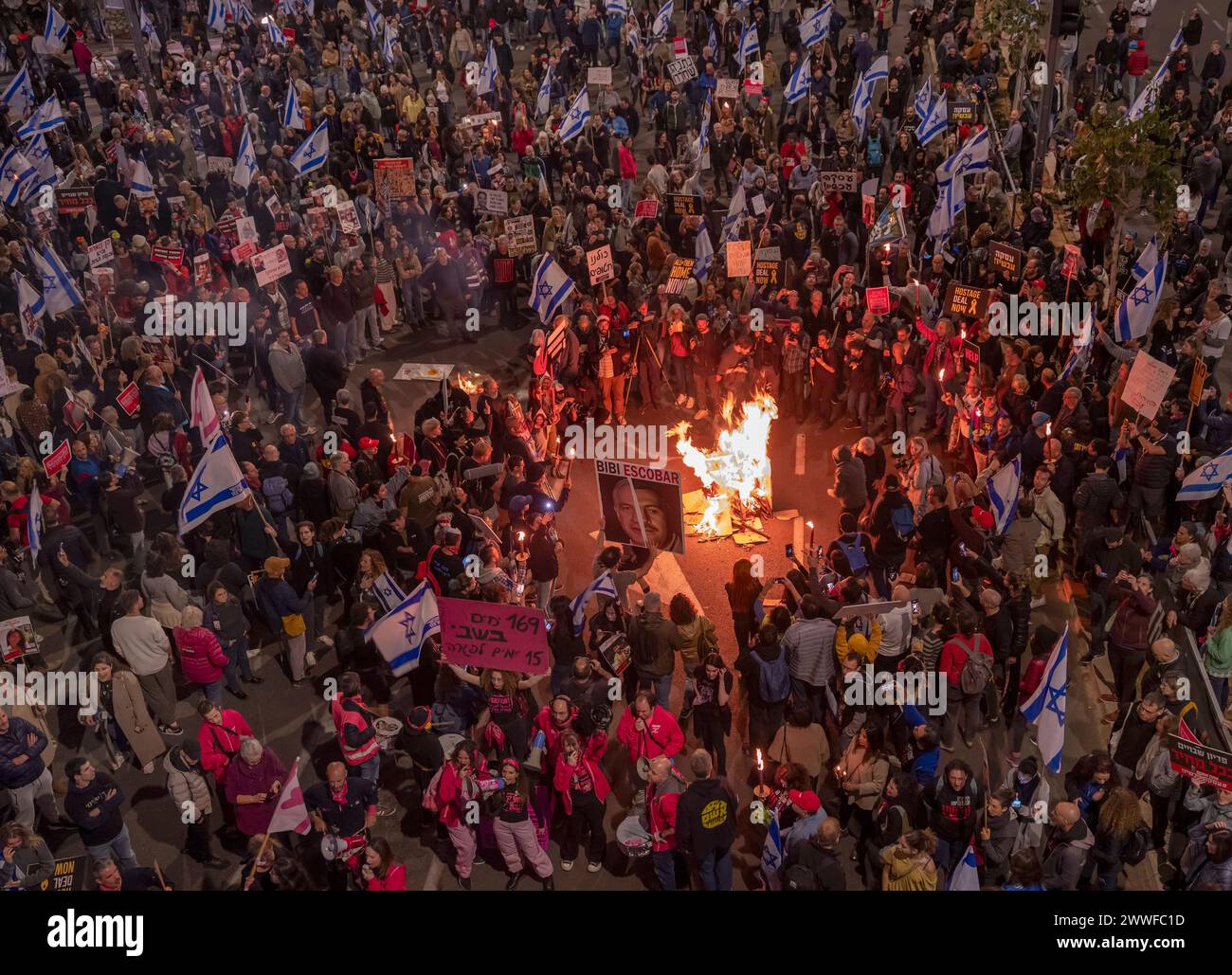 Tel Aviv, Israele. 23 marzo 2024. Gli israeliani si riuniscono intorno a un incendio durante una protesta di massa a Tel Aviv, Israele, il 23 marzo 2024, chiedendo di spodestare il primo ministro Benjamin Netanyahu, per riportare a casa e la pace gli ostaggi detenuti da Hamas. Decine di migliaia di israeliani sono scesi in strada a Tel Aviv e in molte altre città israeliane mentre la guerra contro Hamas nella Striscia di Gaza entra nel suo sesto mese. Foto di Jim Hollander/UPI credito: UPI/Alamy Live News Foto Stock