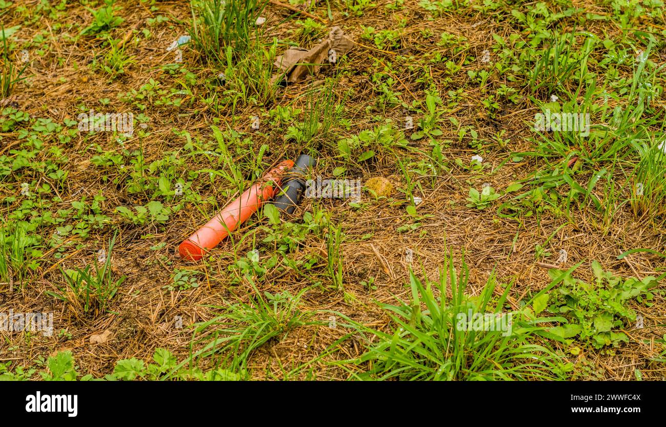 Tubo scartato su terreni erbosi evidenziando il problema degli oggetti lasciati in natura, in Corea del Sud Foto Stock
