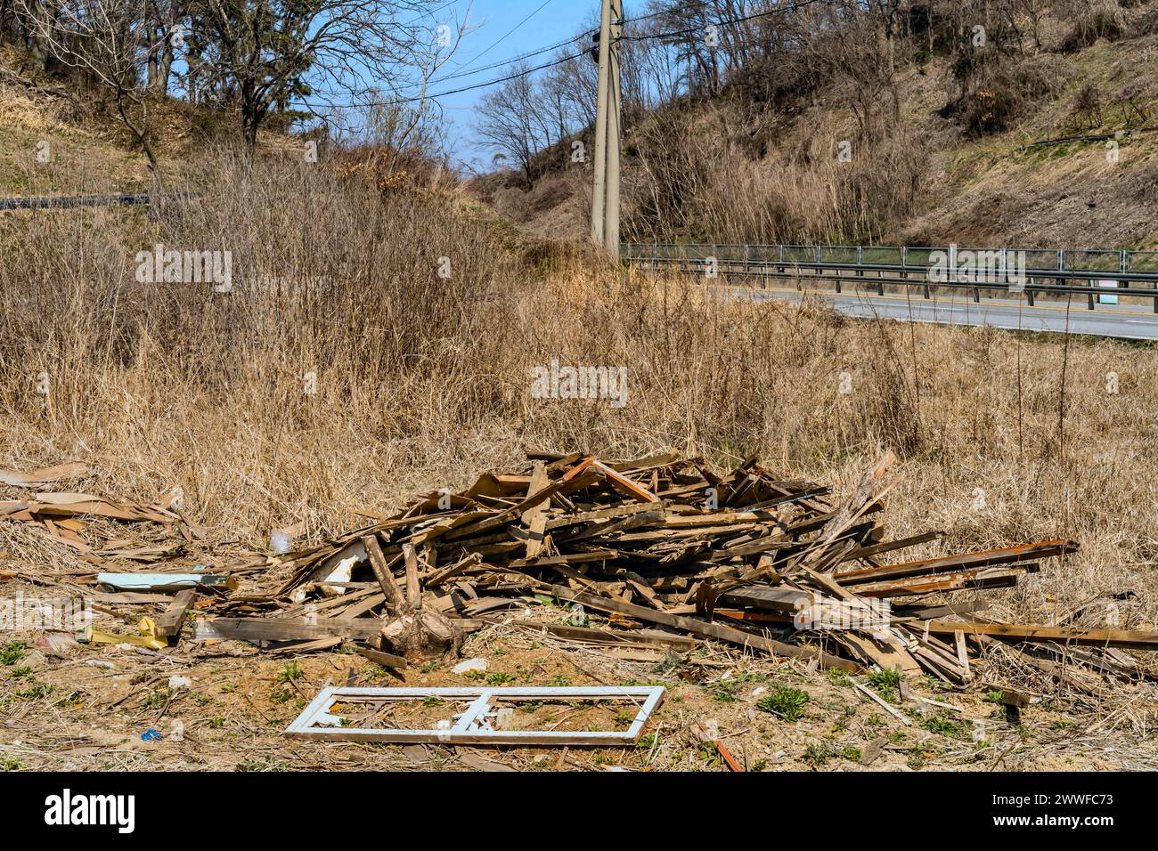 Un mucchio di detriti di legno sparsi in un'area rurale che mostra segni di degrado, in Corea del Sud Foto Stock