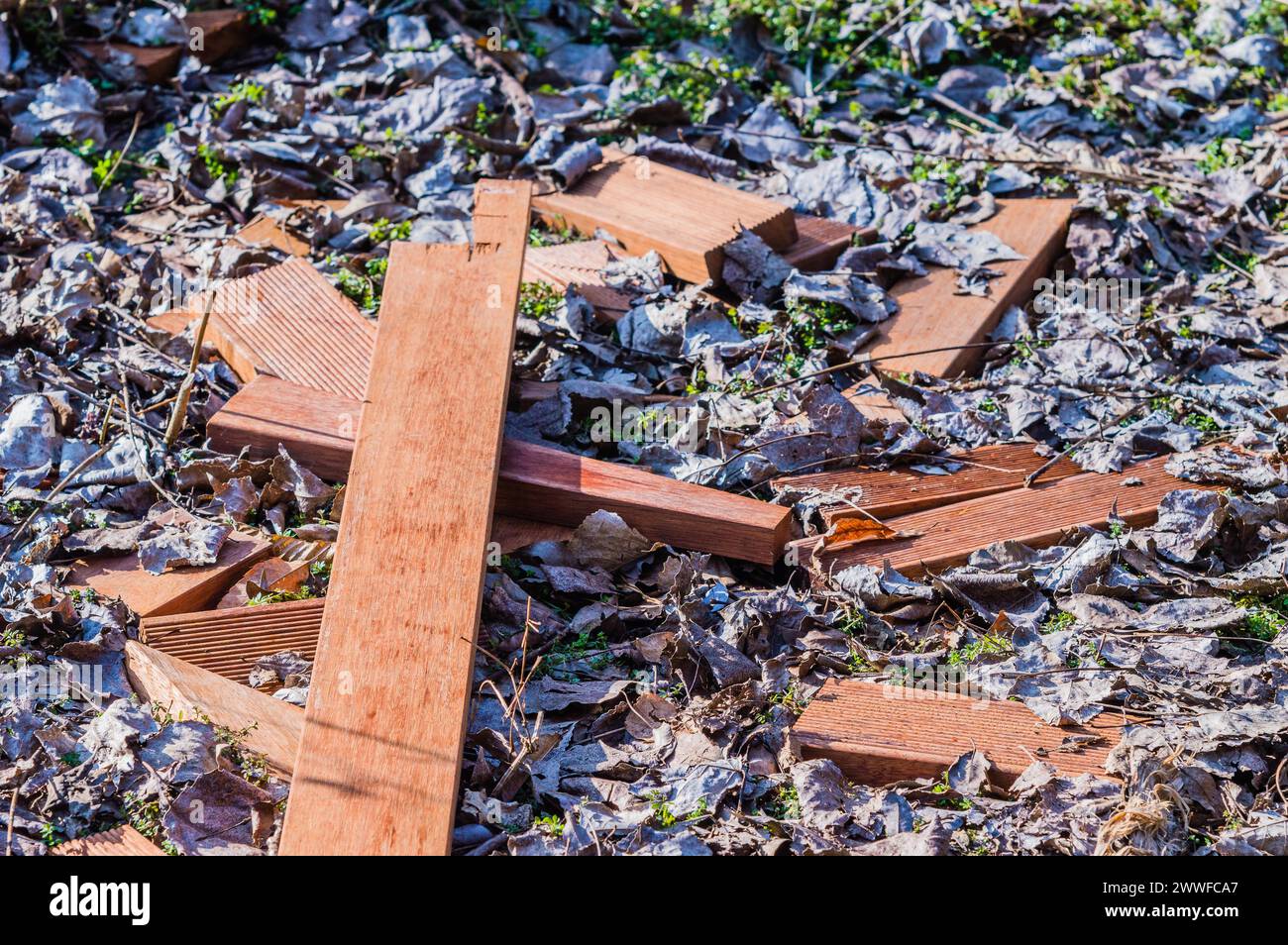I listelli di legno rotti formano una croce sul terreno ricoperta di foglie morte, in Corea del Sud Foto Stock