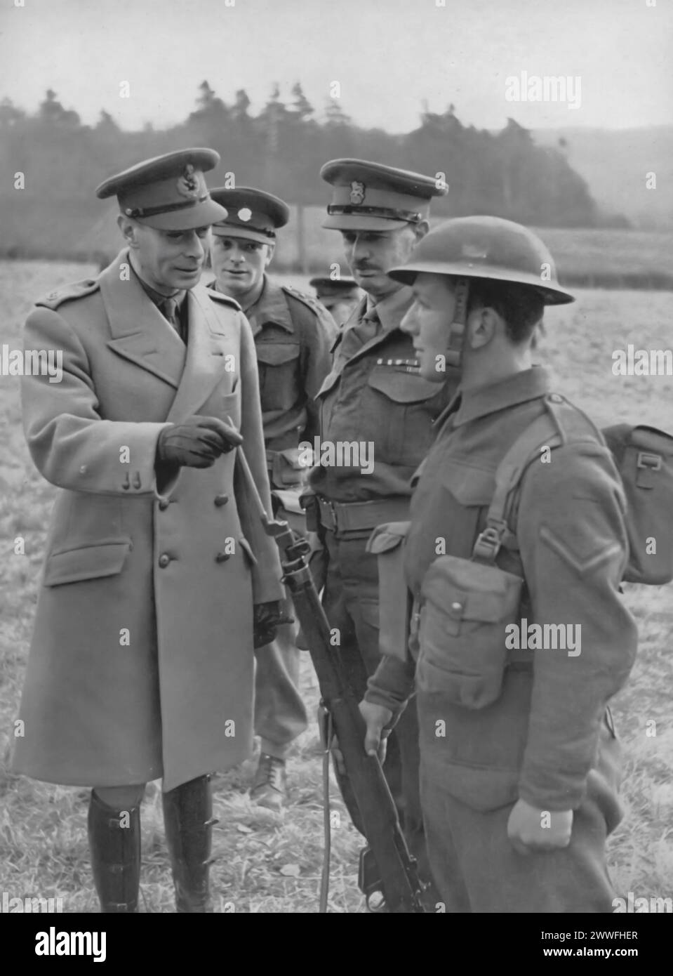 Un fotografo mostra re Giorgio vi in visita alle truppe in Scozia, 1943.questa visita sottolinea l'impegno del re a sostenere e rafforzare il morale del personale militare di stanza in tutto il Regno Unito durante la seconda guerra mondiale. Foto Stock