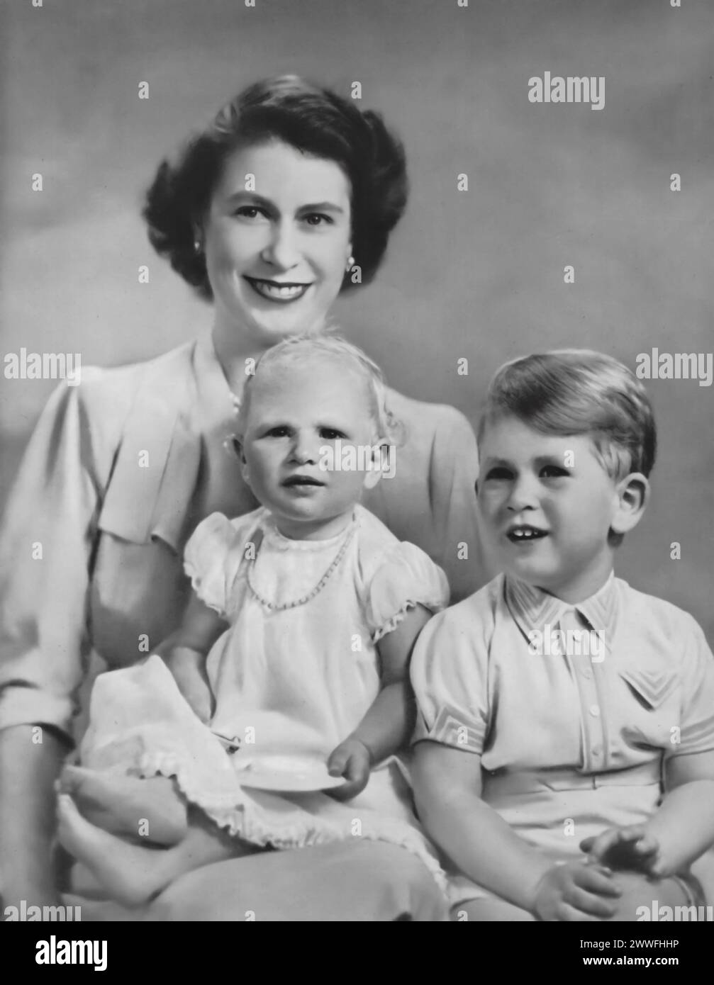 Elisabetta II è raffigurata con i suoi primi due figli, Carlo III e la principessa Anna, in una fotografia scattata intorno al 1951. Questa immagine cattura un momento nella vita della famiglia reale prima della sua ascesa al trono, mostrando i primi anni del futuro monarca e di sua sorella. Foto Stock
