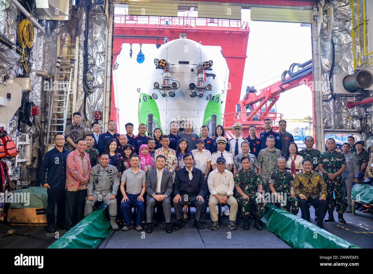 Giacarta, Indonesia. 22 marzo 2024. Gli ospiti posano per delle foto con il sommergibile "Fendouzhe" con equipaggio sulla nave di ricerca scientifica Tan suo Yi Hao (Discovery One) presso il porto Tanjung Priok di Giacarta, Indonesia, 22 marzo 2024. La spedizione scientifica congiunta condotta dall'Accademia cinese delle scienze (CAS) e dall'Agenzia nazionale per la ricerca e l'innovazione indonesiana si è tuffata con successo a 7.178 metri di profondità nella fossa di Giava nell'Oceano Indiano, stabilendo il record di immersione più profondo per l'Indonesia, ha detto sabato il team della spedizione. Crediti: Xu Qin/Xinhua/Alamy Live News Foto Stock