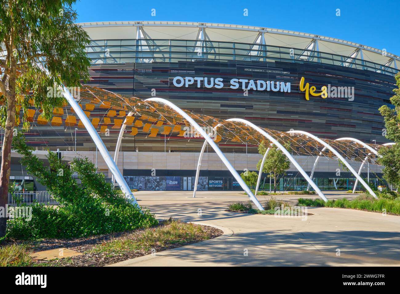Un passaggio pedonale e piante e alberi di fronte all'Optus Stadium, Burswood, Perth, Australia Occidentale. Foto Stock
