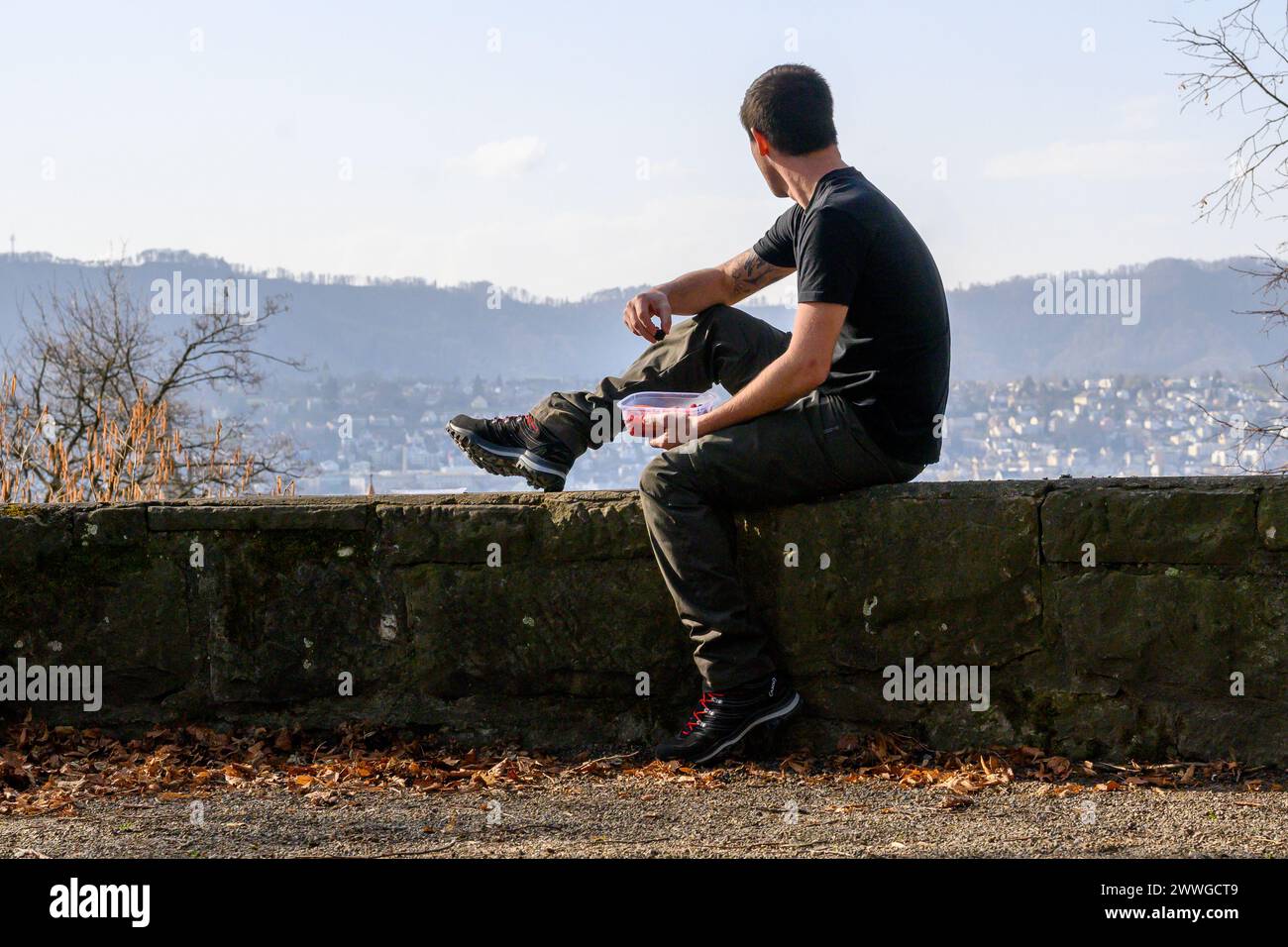 Una figura solitaria gode di un momento tranquillo con uno sfondo urbano. Foto Stock