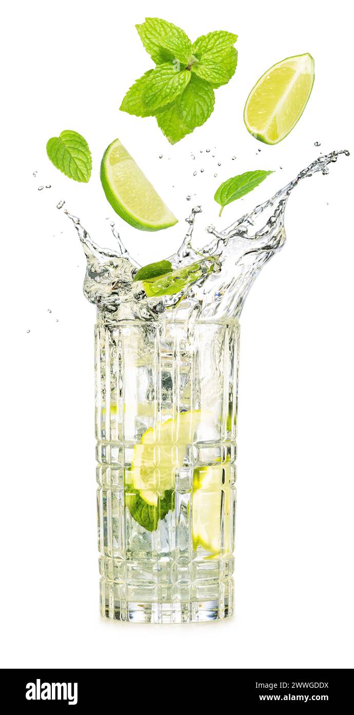 Spicchi di lime e foglie di menta che cadono in un bicchiere traboccante di cocktail mojito isolato su sfondo bianco. Foto Stock