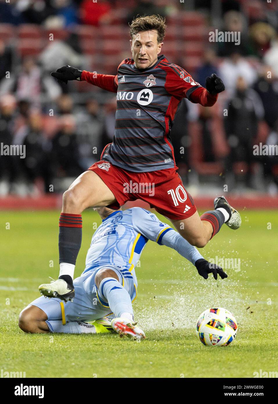 Toronto, Canada. 23 marzo 2024. Federico Bernardeschi (davanti) del Toronto FC salta per evitare uno slide tackle durante la partita di Major League Soccer (MLS) 2024 tra Toronto FC e Atlanta United FC a Toronto, Canada, 23 marzo 2024. Crediti: Zou Zheng/Xinhua/Alamy Live News Foto Stock