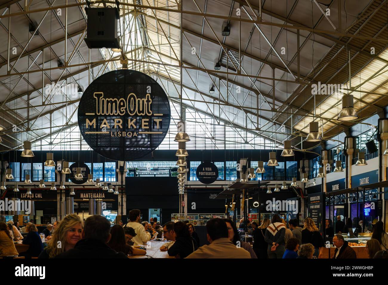 Gruppo di persone sedute a tavoli nel mercato Time Out, l'area alimentare di Lisbona, Portogallo. 2 febbraio 2024. Foto Stock