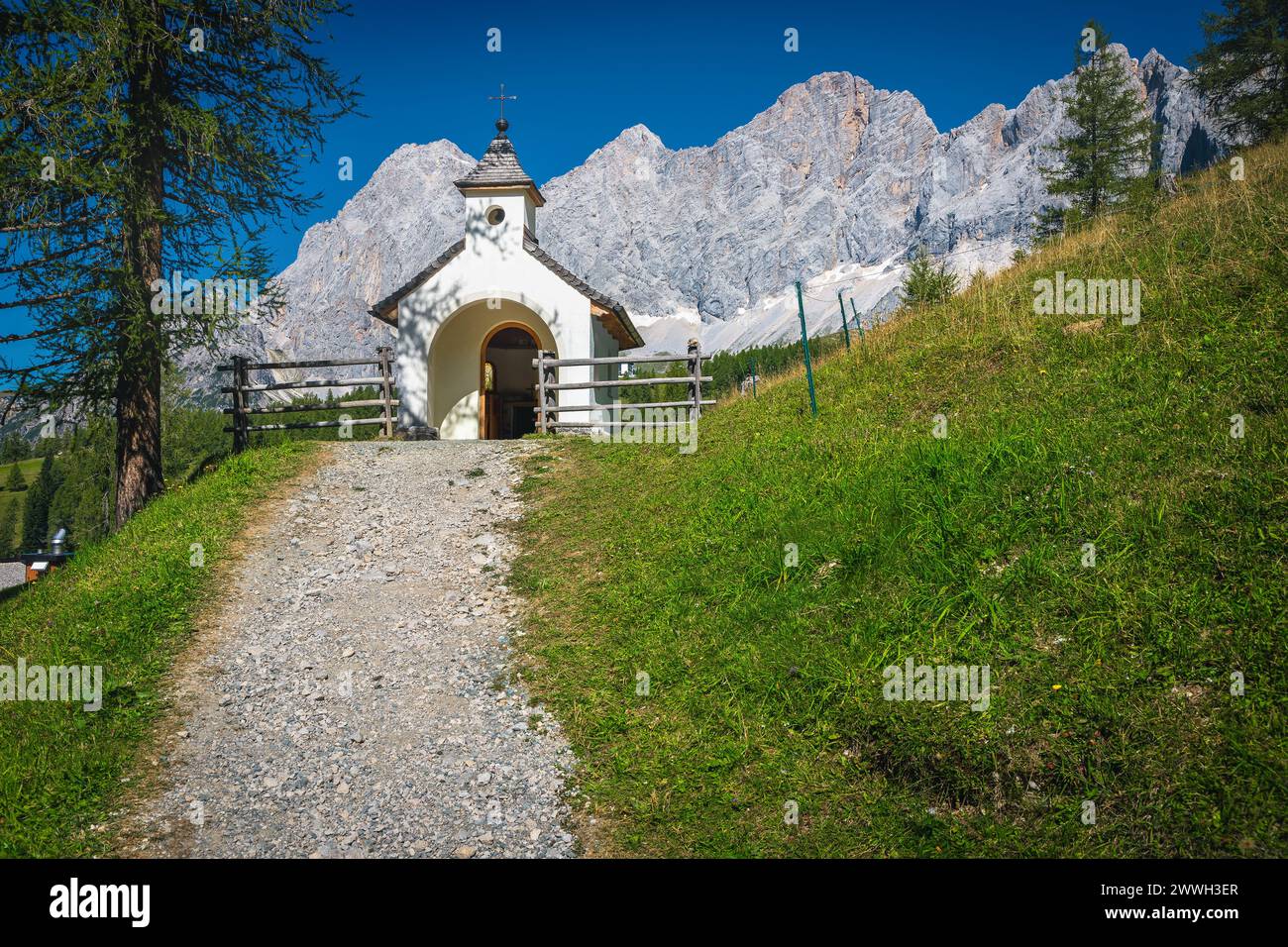 Graziosa piccola cappella alpina sul pendio verde e splendide montagne di Dachstein sullo sfondo, Ramsau am Dachstein, Stiria, Austria, Europa Foto Stock