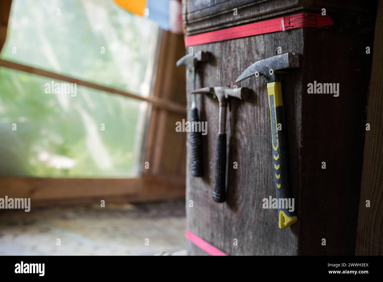 Un martello in legno con testa in ferro appesa in un'officina Foto Stock