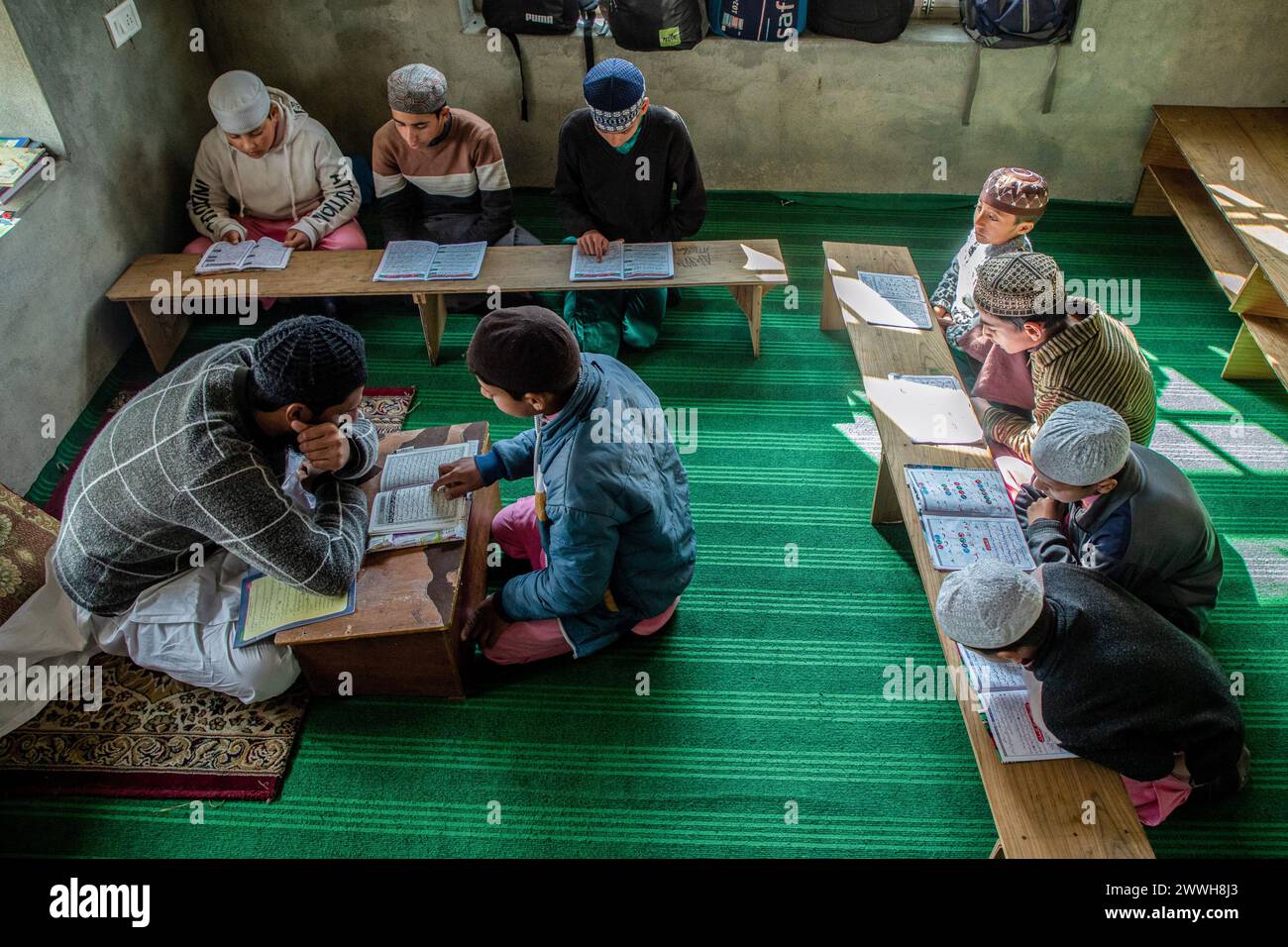 Gli studenti musulmani leggono il Corano davanti al loro insegnante religioso in una scuola islamica o madrasa a Srinagar. Un tribunale in India ha sostanzialmente vietato le scuole islamiche nello stato più popoloso del paese, l'Uttar Pradesh, chiedendo che milioni di studenti siano spostati verso scuole convenzionali, in una mossa che individua i musulmani più avanti rispetto alle elezioni nazionali. Questa mossa scioglierà 2,7 milioni di studenti e circa 10.000 insegnanti in 25.000 scuole islamiche, ha detto il capo del Consiglio di istruzione madrasa nello stato. L'Uttar Pradesh, uno stato indiano nella parte nord-orientale, è sede di One-Fif Foto Stock