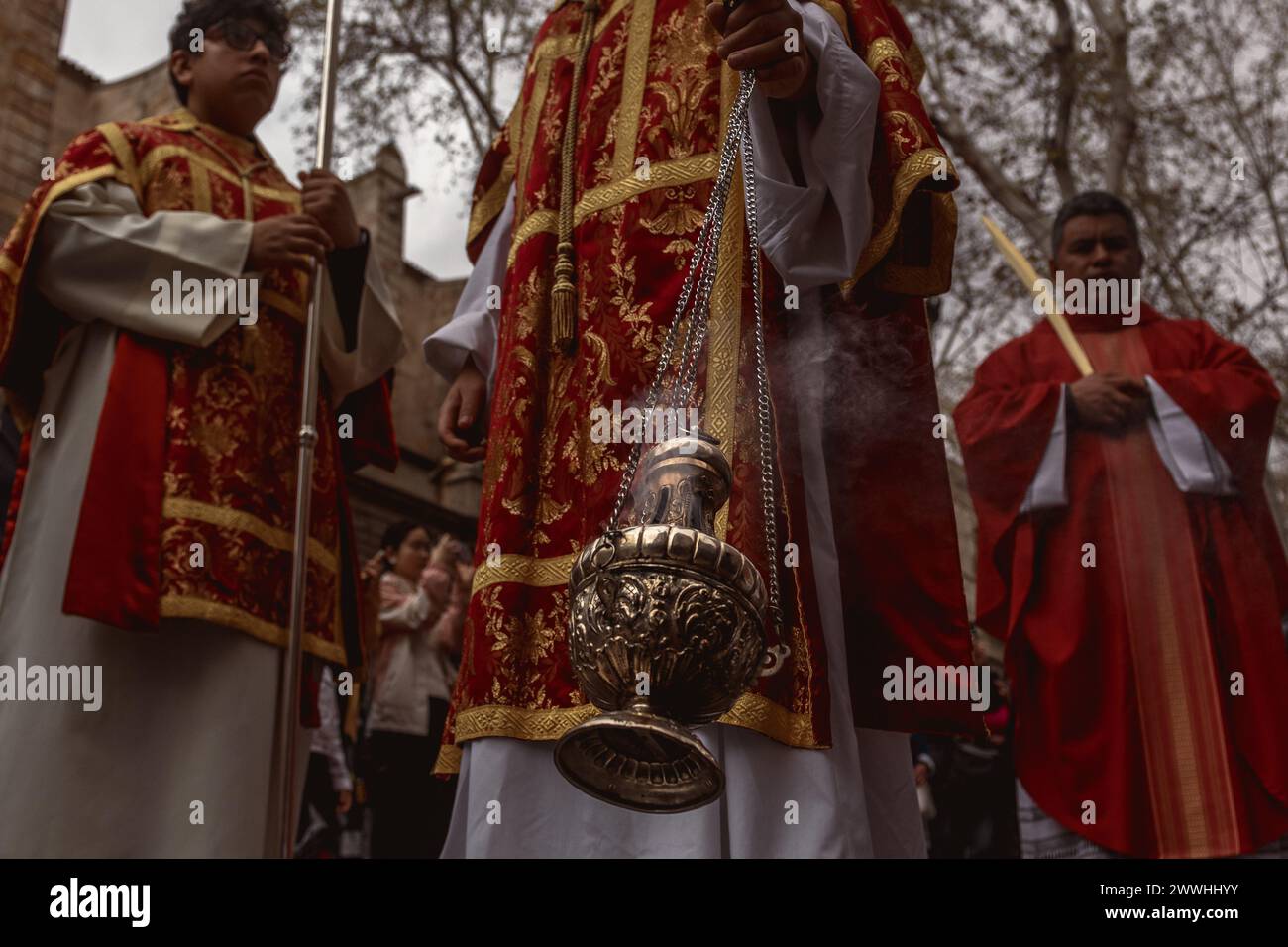 Barcellona, Spagna. 24 marzo 2024. Un allievo della fratellanza "Gran Poder e Macarena Esperanza" cammina per la strada sventolando incenso durante la processione della domenica delle Palme a Barcellona credito: Matthias Oesterle/Alamy Live News Foto Stock