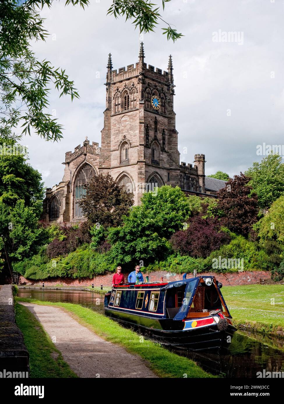 Barca stretta che entra nella chiusa dello Staffordshire e del Worcester Canal, a Kidderminster, con la chiesa di St Mary sullo sfondo, Inghilterra, Regno Unito, Gran Bretagna Foto Stock