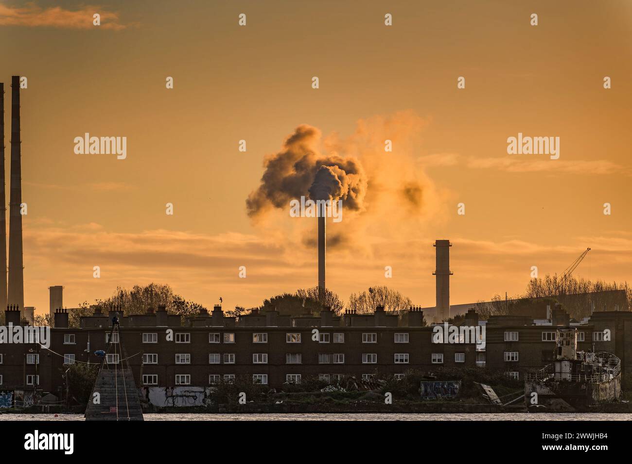 Fumo proveniente dal camino sopra edifici antichi al Grand Canal Dock all'alba di Dublino. Irlanda. Foto Stock