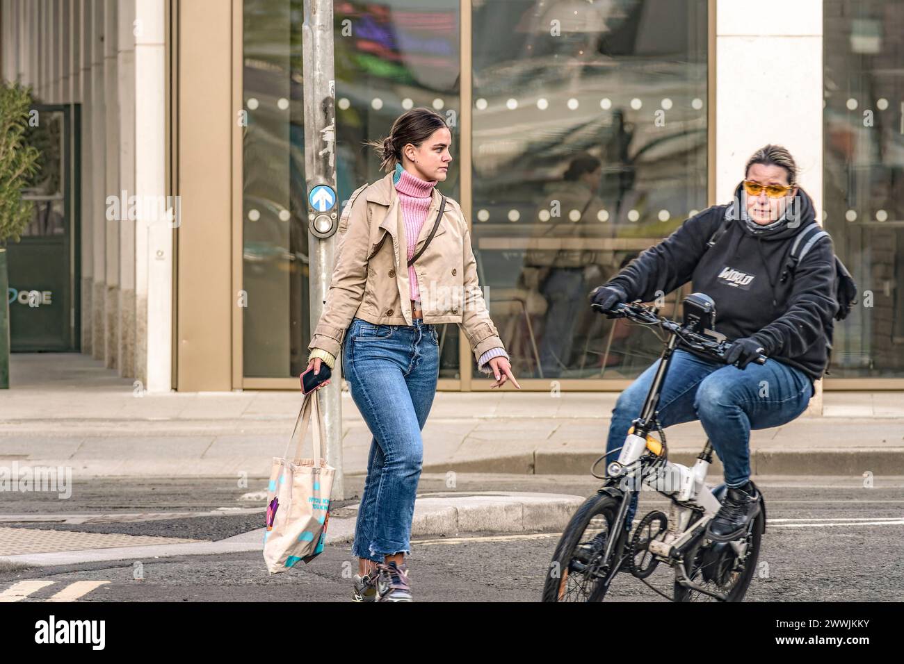 Donna pedonale e ciclista sulla strada. Dublino. Irlanda. Foto Stock