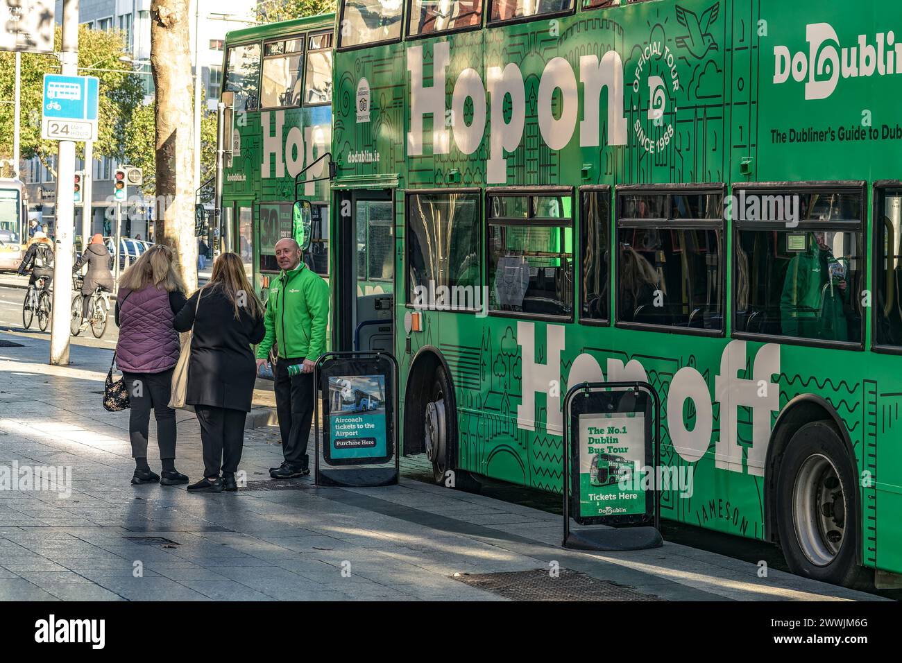 L'autista dell'autobus Hop-On Hop-Off invita i turisti al tour in autobus turistico della città. O'Connell Street, Dublino. Irlanda. Foto Stock