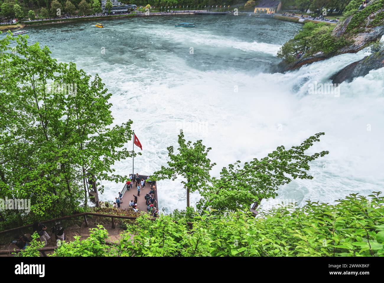 Descrizione: I turisti osservano le imponenti cascate accanto al castello di Laufen alle cascate del Reno dalla piattaforma e dalle barche turistiche. Cascate del Reno, Neuhause Foto Stock