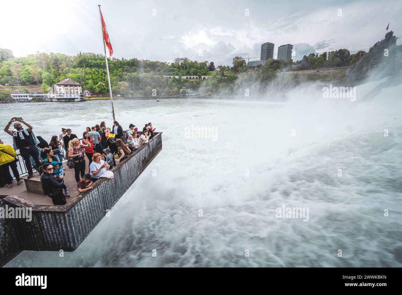 Descrizione: I turisti apprezzano le massicce inondazioni d'acqua delle possenti Cascate del Reno dalla piattaforma di osservazione. Cascate del Reno, Neuhausen am Rheinfall, Schaffh Foto Stock