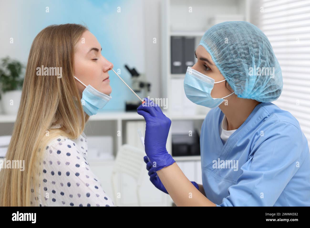 Analisi di laboratorio. Medico che preleva il campione dal naso del paziente con un tampone di cotone in ospedale Foto Stock