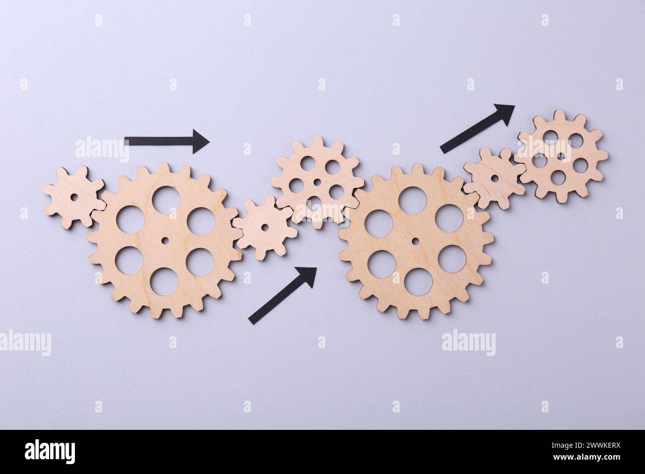 Organizzazione e ottimizzazione dei processi aziendali. Schema con figure in legno e frecce sullo sfondo lilla, vista dall'alto Foto Stock