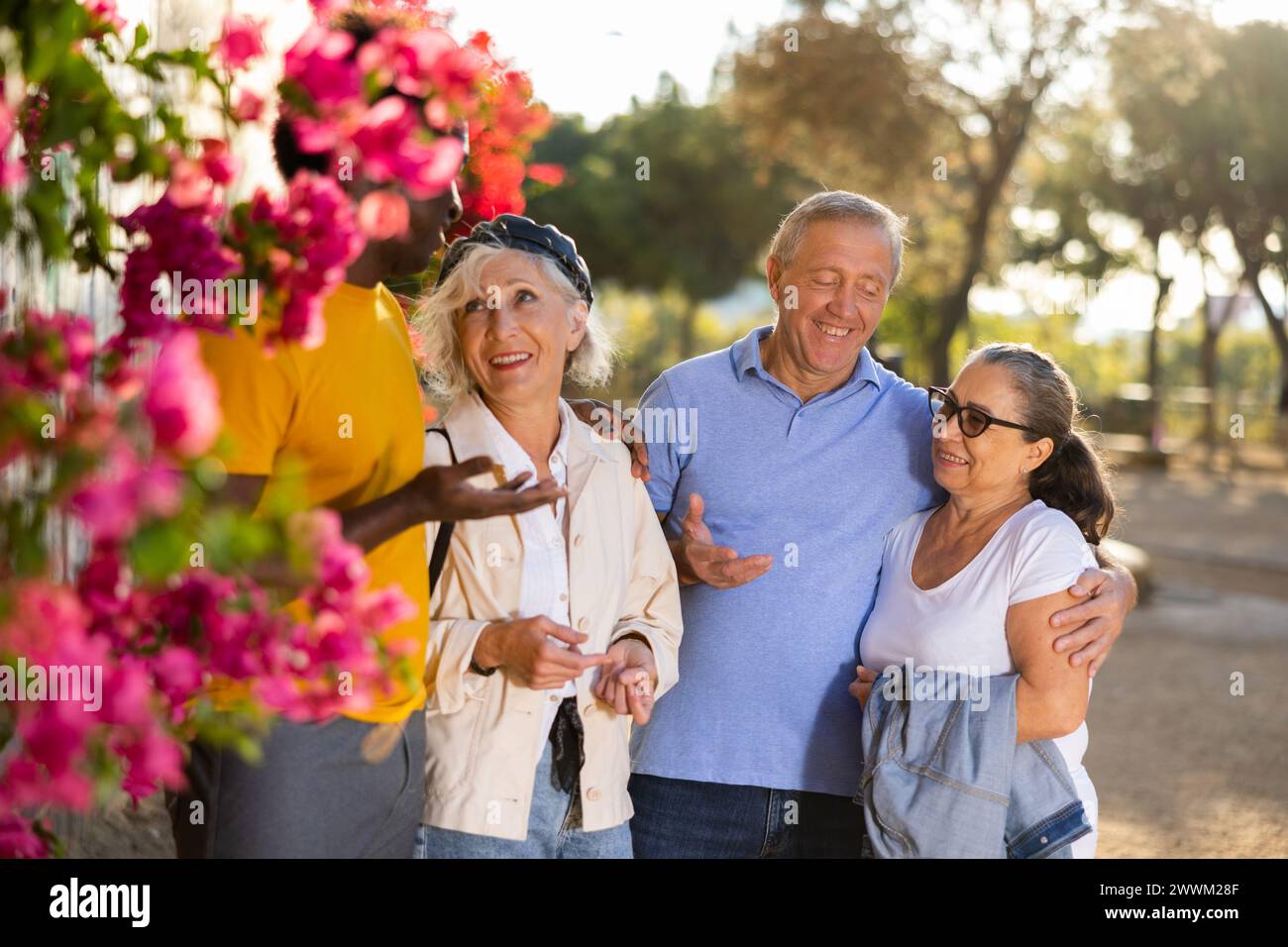 Un gruppo di persone adulte amichevoli e multirazziali che stanno fuori a parlare tra loro Foto Stock