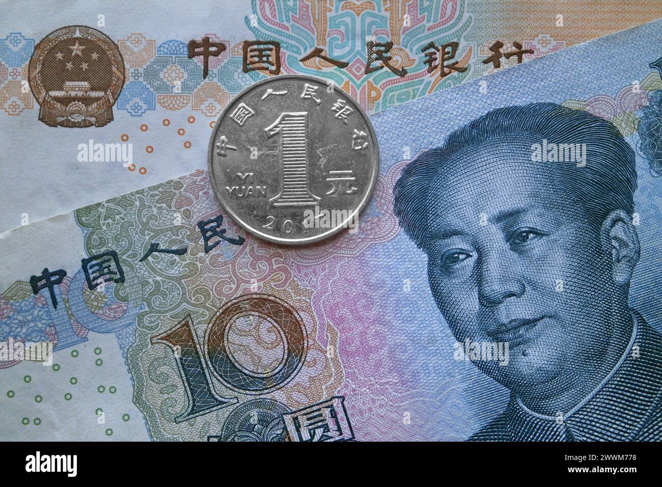 Una moneta da 1 yuan sopra una banconota da 10 yuan e una banconota da 20 yuan. Foto Stock