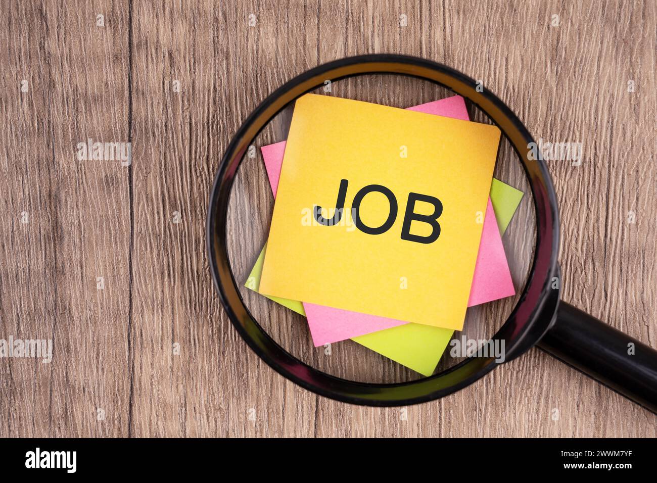 Lente d'ingrandimento e nota adesiva con LAVORO a parole Foto Stock