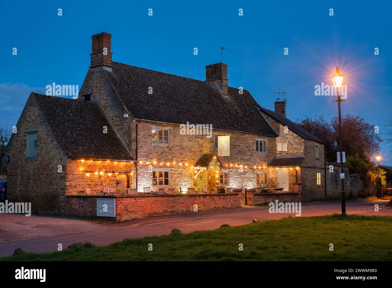 Il pub White Horse al crepuscolo. Kings Sutton, Northamptonshire, Inghilterra Foto Stock