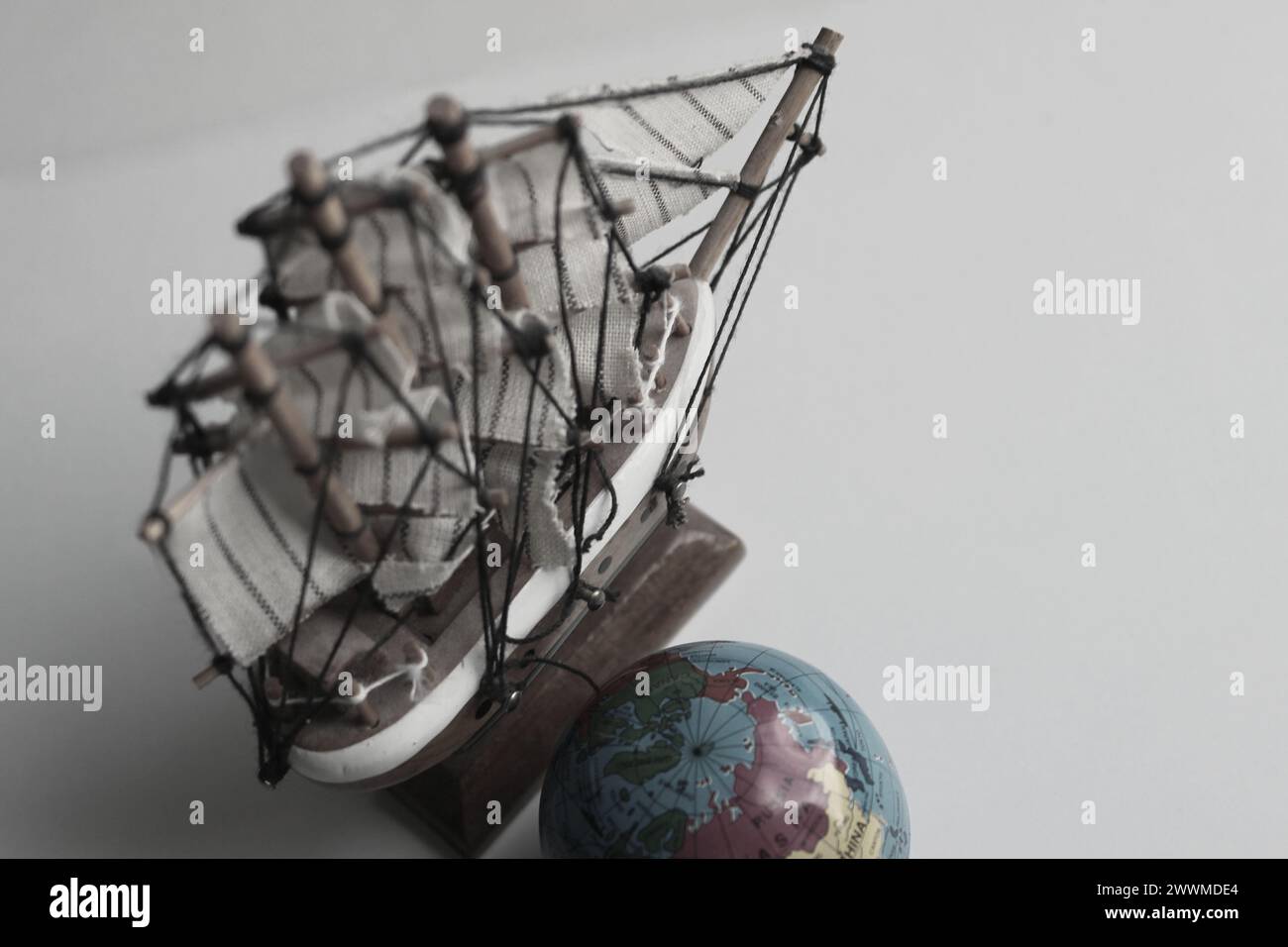 Immagine del concetto di Sea Travel. Mappamondo e modello in legno della vecchia nave in stile colori tenui Foto Stock Immagine del concetto di Sea Travel. Mappamondo e modello in legno della vecchia nave in stile colori tenui Foto Stock