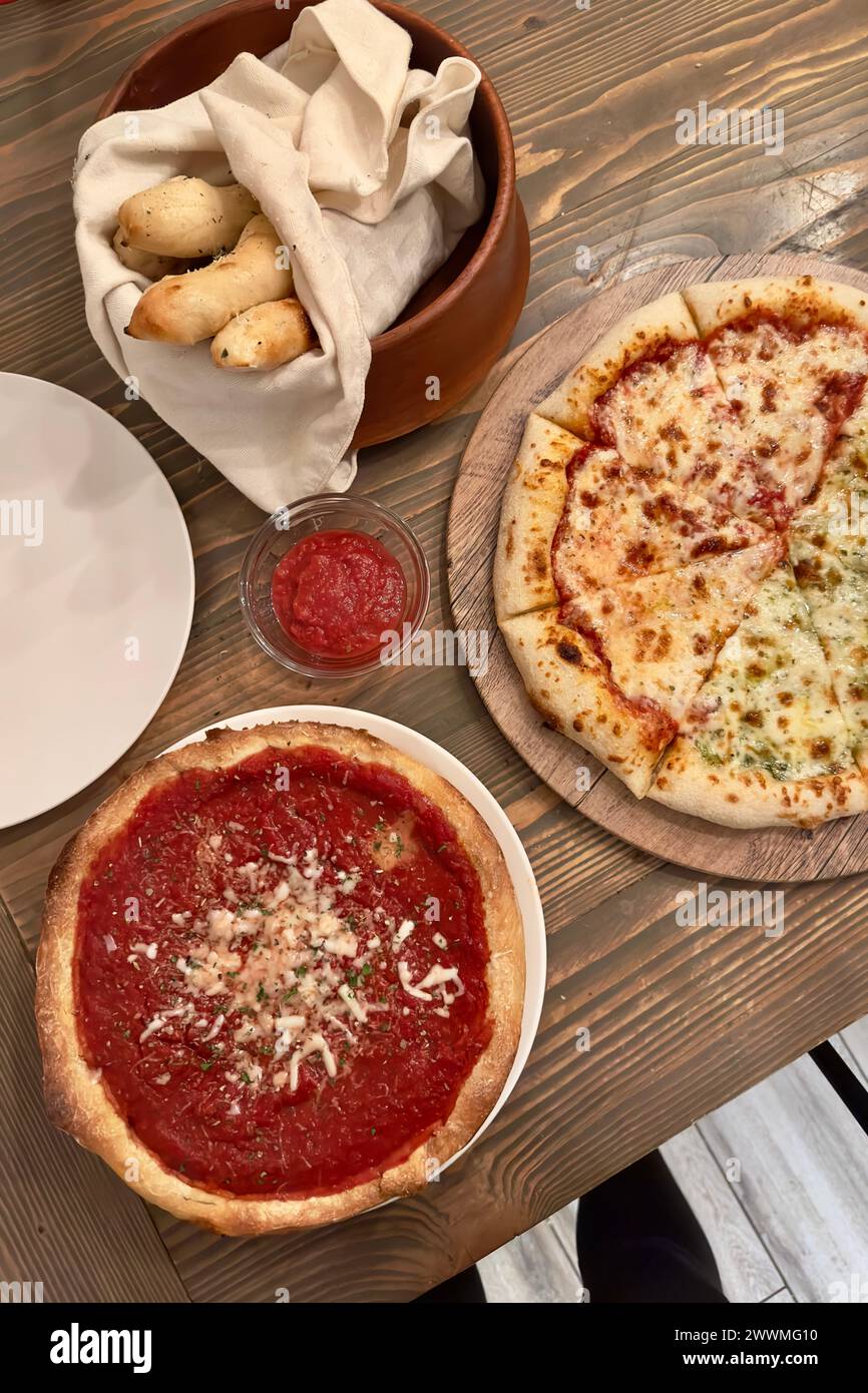 Breakstick per pizza fatti in casa in una ciotola di legno, pizza a metà piatto Foto Stock