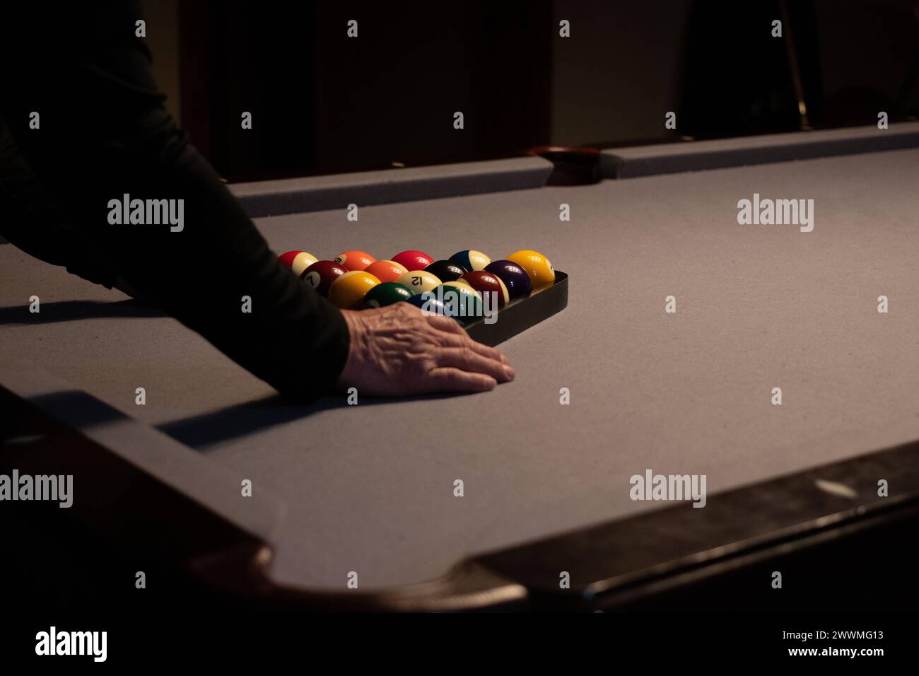 Primo piano di un uomo che racchiude palle da biliardo Foto Stock