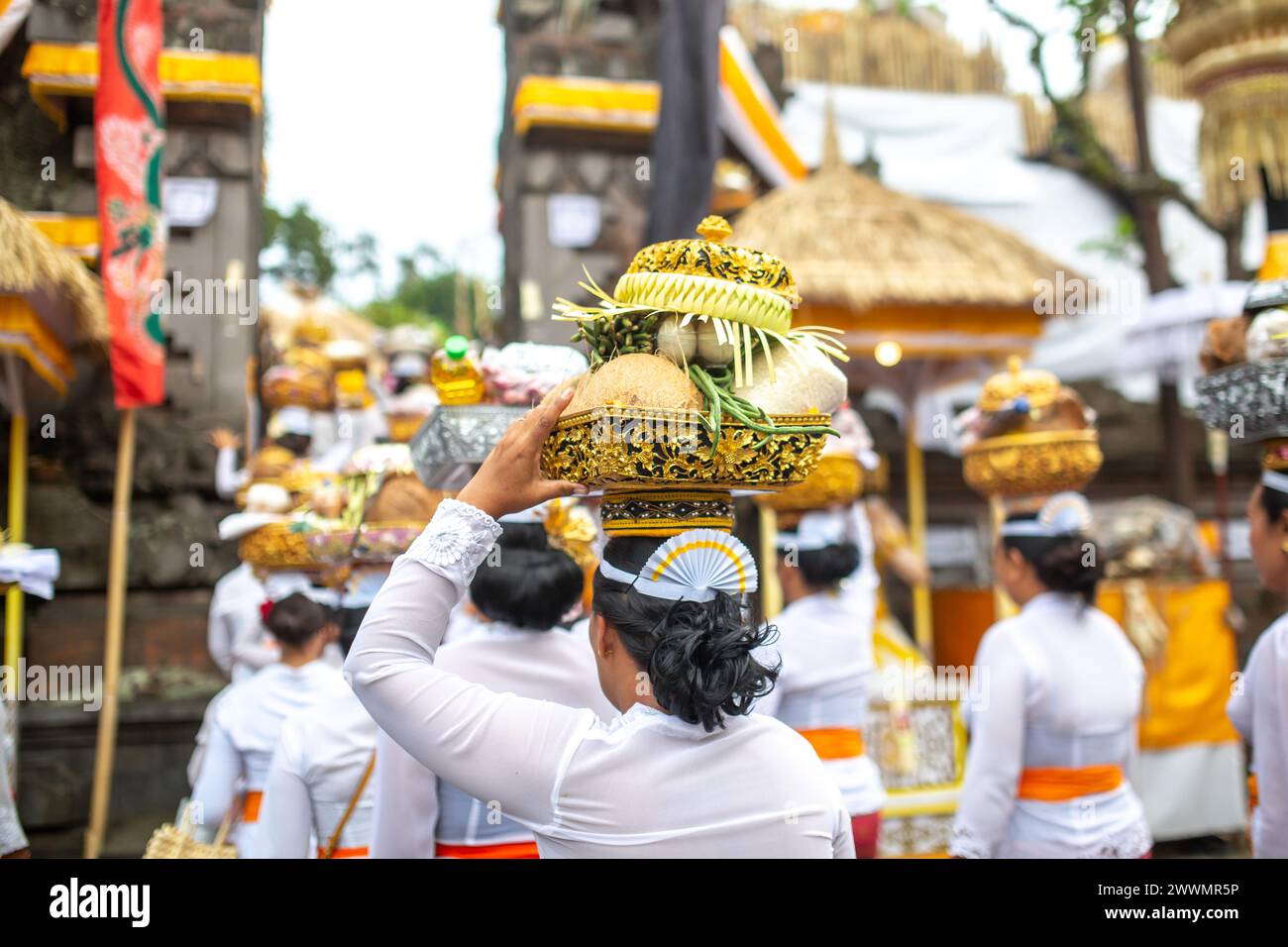 Un gruppo di donne irriconoscibili durante una cerimonia tradizionale di fronte a un tempio Foto Stock