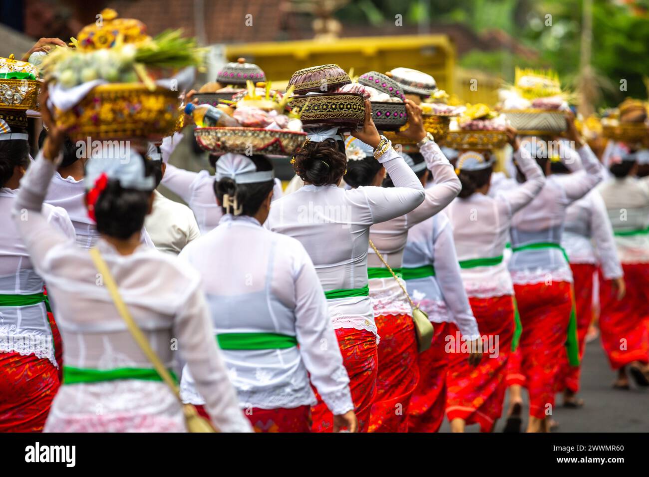 Un gruppo di donne irriconoscibili durante una cerimonia tradizionale di fronte a un tempio Foto Stock