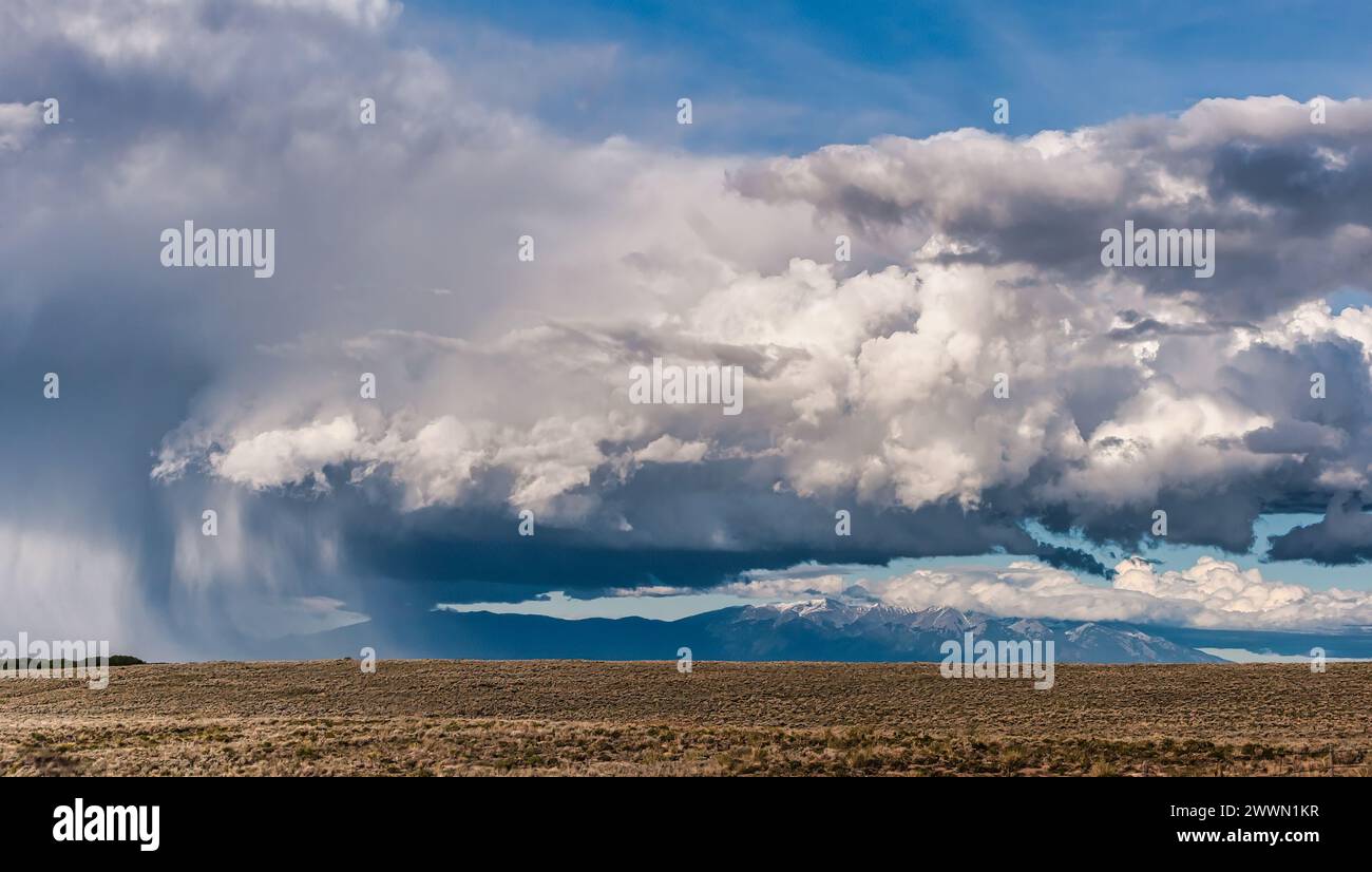 Immagine sorprendente che mostra una tempesta imminente con nuvole spettacolari su un paesaggio sparso e desolato e montagne lontane Foto Stock