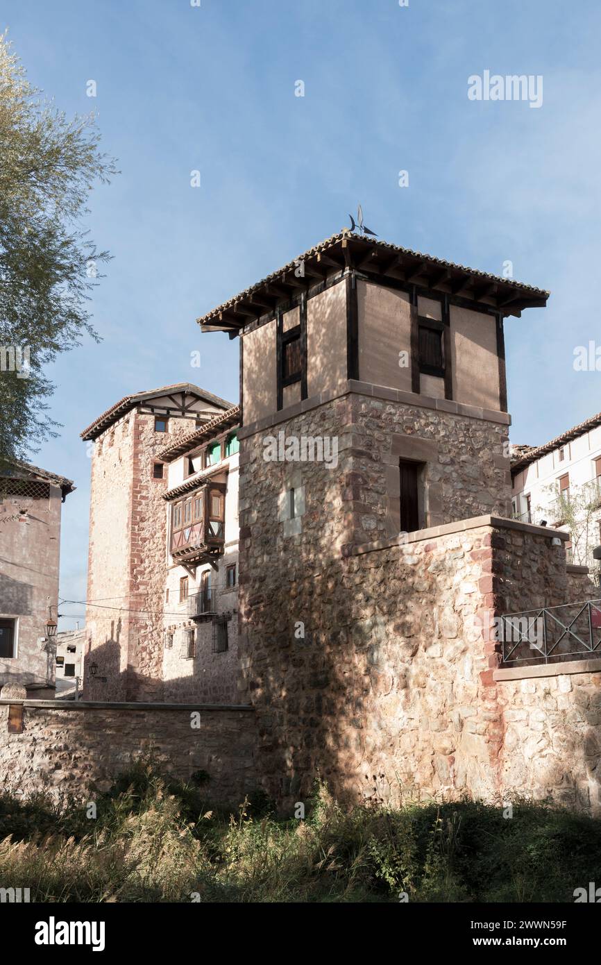 edifici in pietra con elementi in legno, circondati dal verde sotto un cielo limpido, che mostrano architettura storica e bellezze naturali Foto Stock