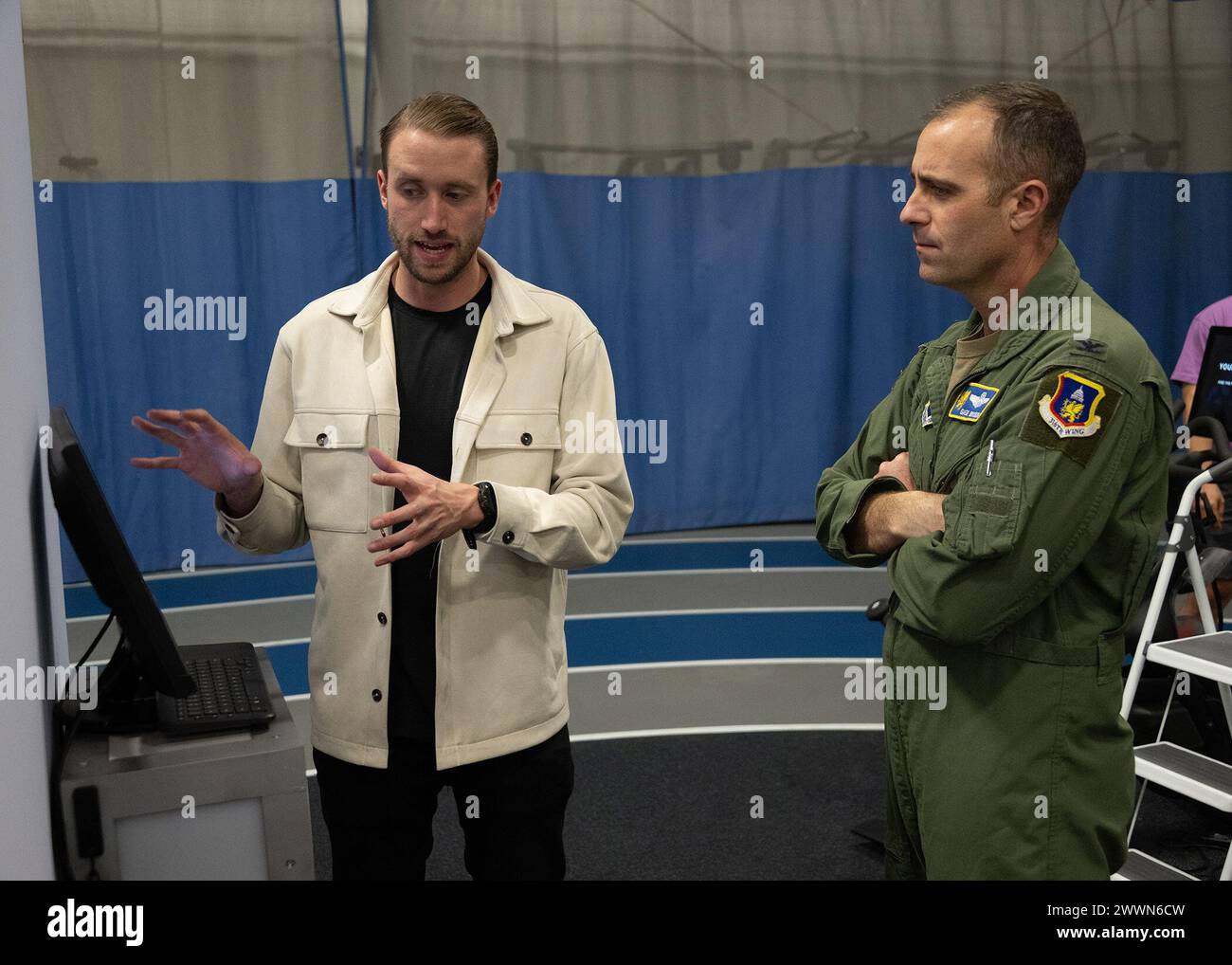 Brandon Murphy, a sinistra, capo della crescita a Lumena, parla con il colonnello dell'aeronautica statunitense Parkin C. "Gage" Bryson, vice comandante del 316th Wing, su come creare un account MindGym presso il Tactical fitness Center presso Joint base Andrews, Md., 9 febbraio 2024. La MindGym è progettata per addestrare la risposta cognitiva degli Airmen e per migliorare le loro funzioni cerebrali. Aeronautica militare Foto Stock