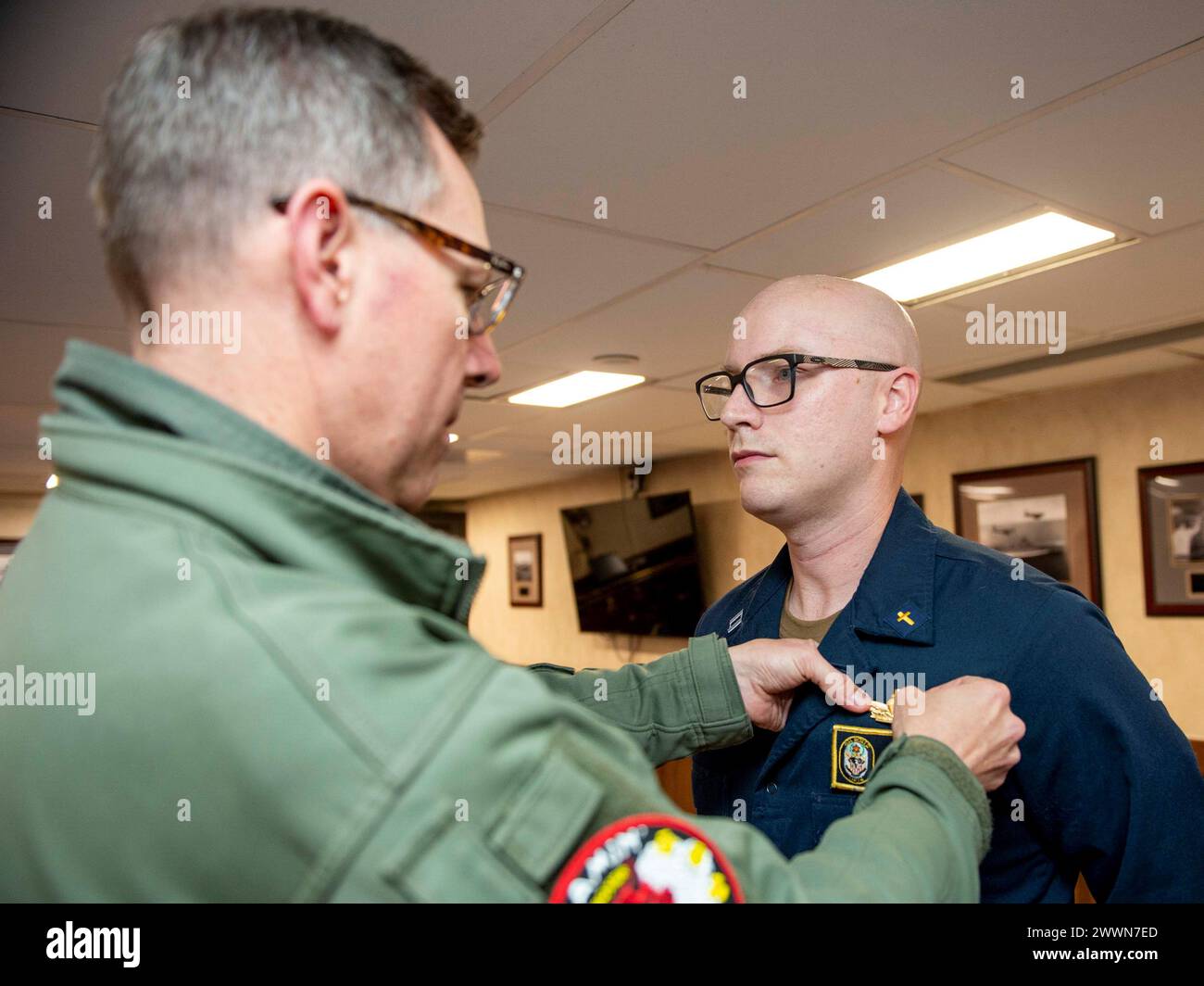 L'ufficiale comandante della USS Boxer (LHD 4), il capitano Brian Holmes, affianca il cappellano di superficie pin sul tenente Kevin Gilchrist, vice cappellano e nativo di Glenwood, Iowa, durante una cerimonia nella sala di guerra. Boxer è una nave d'assalto anfibia della classe Wasp portata a San Diego. Marina Foto Stock