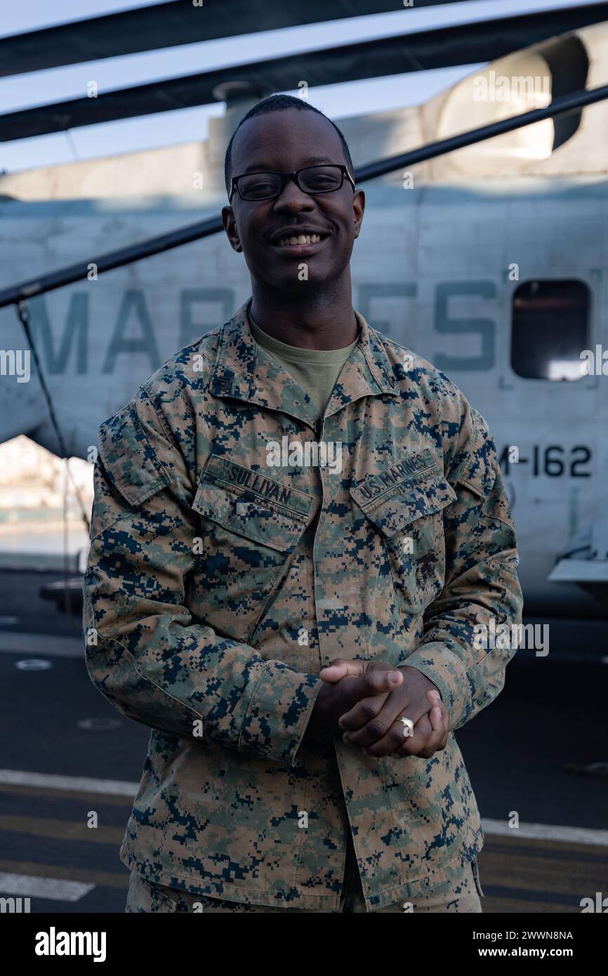 Leniyus Sullivan, un nativo della Carolina del Nord e un tecnico di riparazione di armi di piccolo calibro con la 26th Marine Expeditionary Unit (Special Operations Capable) (MEU(SOC)), posa per una foto a bordo della nave d'assalto anfibia classe Wasp USS Bataan, 11 febbraio 2024. Sullivan fa parte del corpo dei Marines da quasi 4 anni e dice che gli ha dato l'opportunità di provvedere alla sua famiglia. "Il corpo dei Marines mi ha dato l'opportunità di essere un fornitore per la mia famiglia, di essere il primo nella mia famiglia ad avere effettivamente una carriera, e mi ha aiutato a diventare finanziariamente stabile mentre gestivo una famiglia". Foto Stock