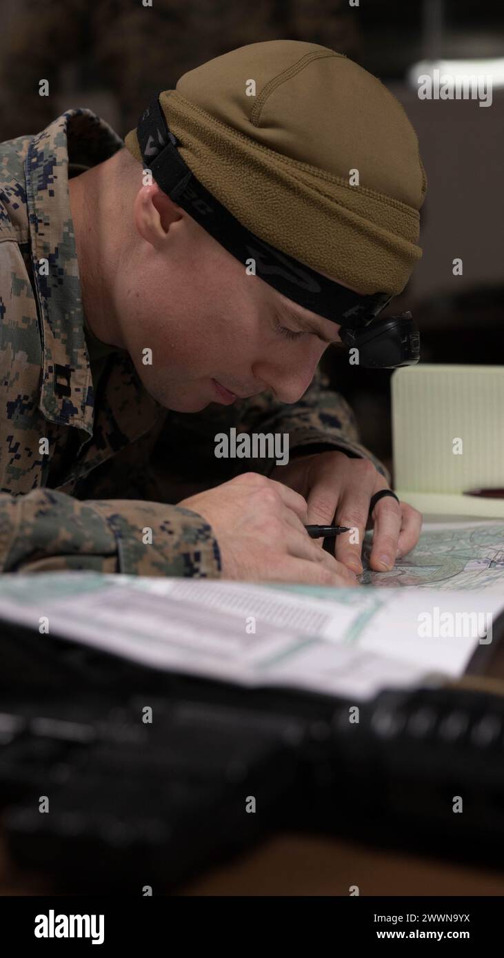 Il capitano Daniel Burton, un ufficiale di fanteria del 1st Battalion, 6th Marine Regiment, 2d Marine Division (MARDIV) e un nativo del Michigan, mappa i punti di griglia durante un test di abilità della fanteria come parte del Division Leaders Assessment Program (DLAP) a Fort Walker, Virginia, 23 febbraio 2024. DLAP è un corso rigoroso che testa e migliora le capacità di combattimento dei leader in 2d MARDIV. Corpo dei Marine Foto Stock