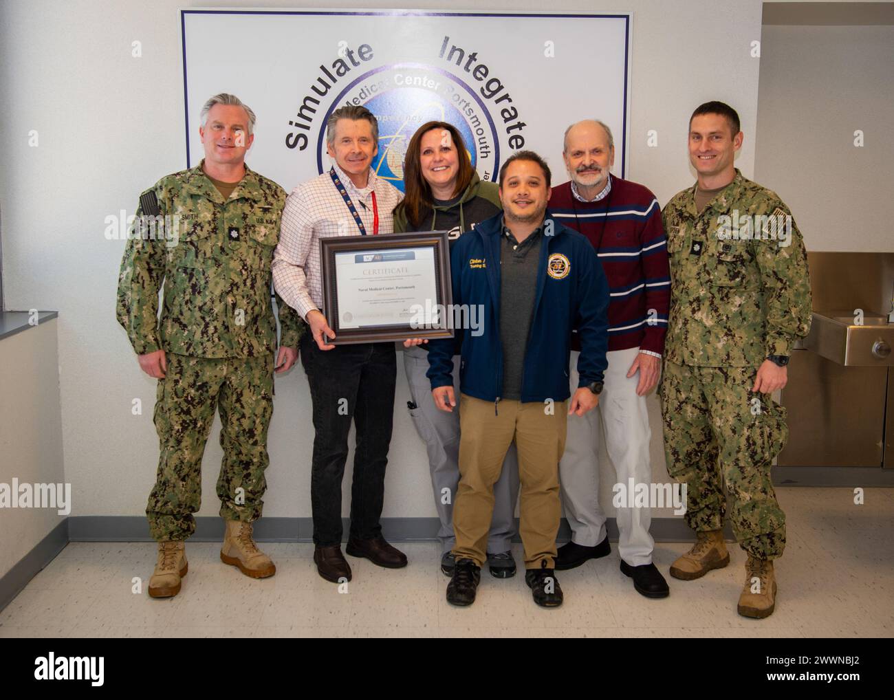 Healthcare Simulation and Bioskills Training Center (HSBTC) staff con il certificato di riaccreditamento American College of Surgeons (ACS). Da sinistra, cmdr. Chris Smith, vicedirettore HSBTC; Don Delorey, ricercatore; Rebecca Kiser, capo infermiere educatore; Clint Rombaoa, responsabile del Centro di simulazione; Jon Lorenz, responsabile del Centro Bioskills; cm. Levi Kitchen, direttore HSBTC. I membri del team HSBTC non illustrati sono cmdr. Tamara Kemp, direttore chirurgico, e cmdr. Liza Stone, direttore infermieristico. Foto Stock