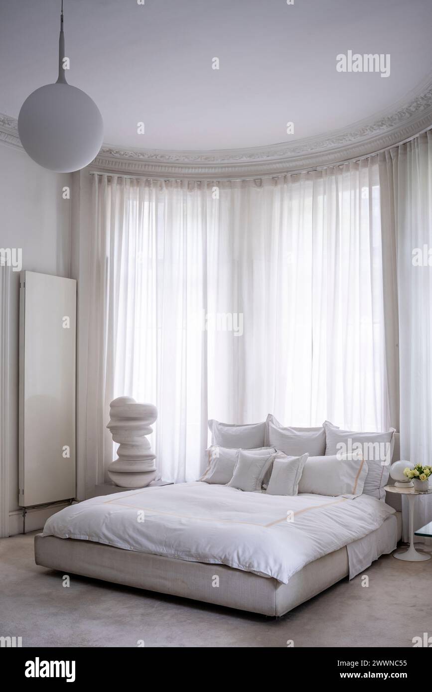 Camera da letto bianca con scultura d'arte moderna nell'appartamento West London, Regno Unito Foto Stock